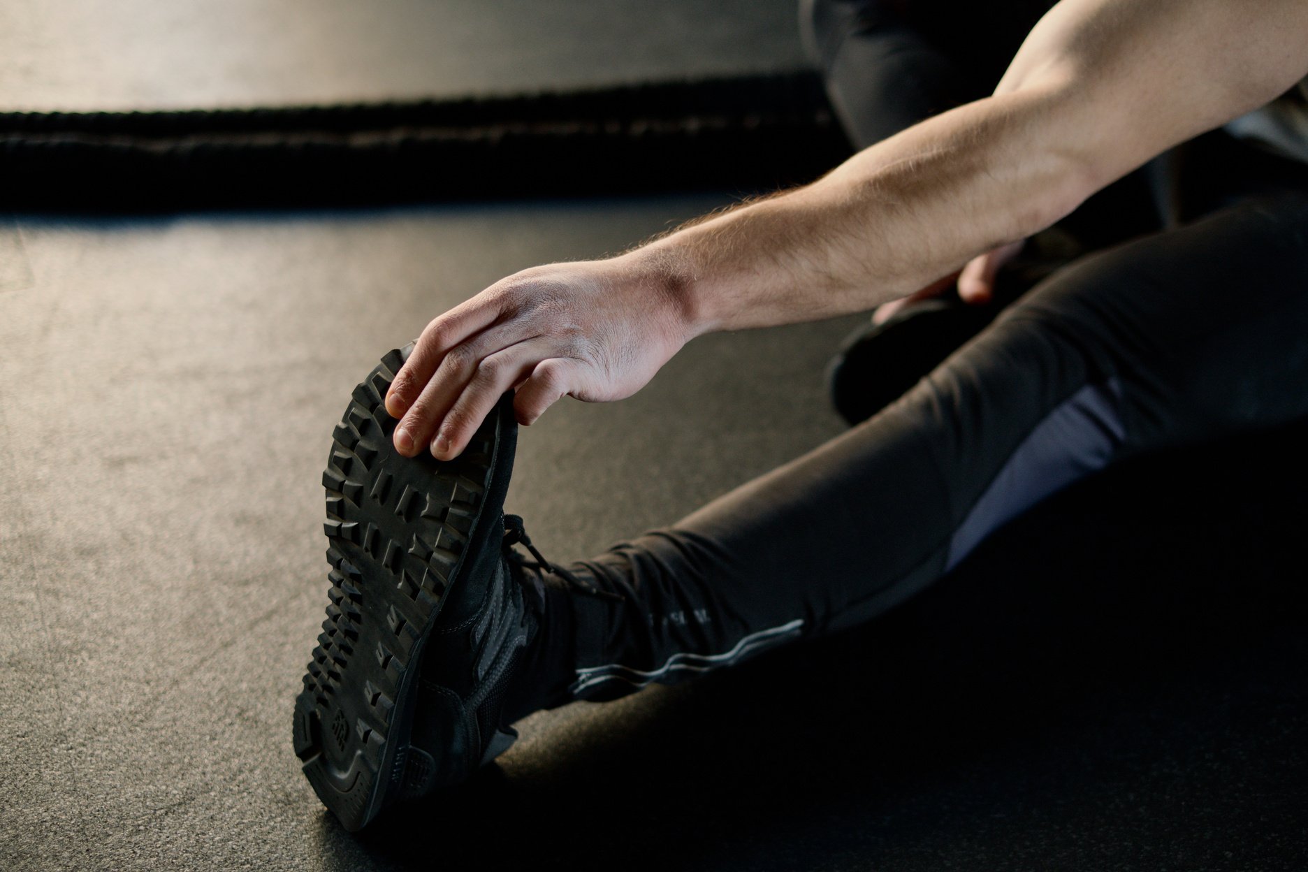 Person Holding his Foot and Stretching